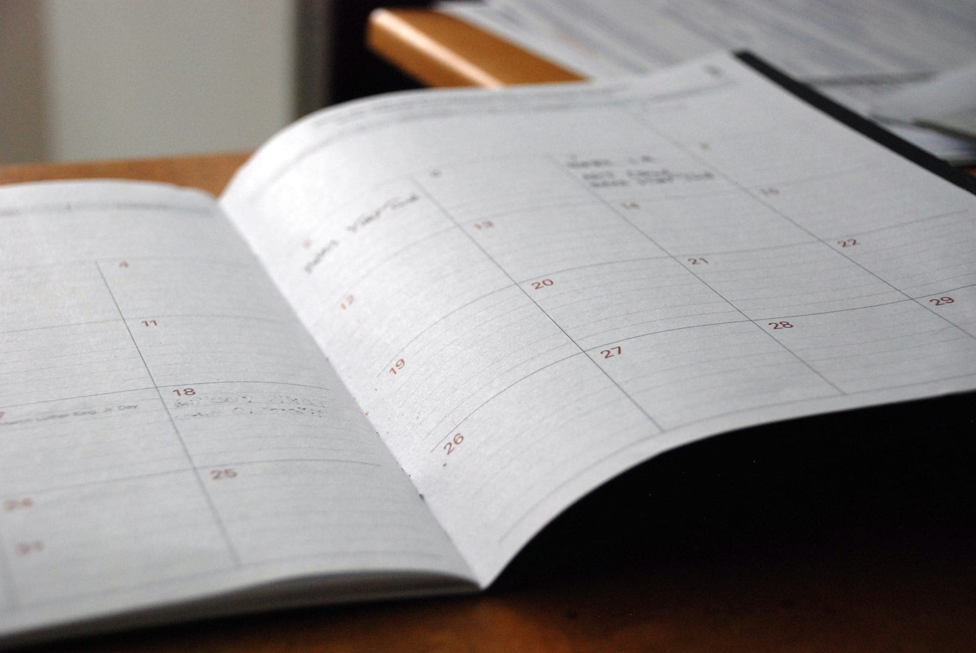 An open planner on a wooden desk